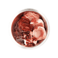 Metal bowl with raw pork cuts and organs, branded True Carnivores, showcasing 100 Mile Raw Just Pork, a locally sourced, boneless pet food mix.