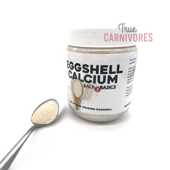 Back2Basics Powdered Eggshell by True Carnivores; a plastic jar with finely crushed eggshell calcium, featuring a heaped spoon beside it.