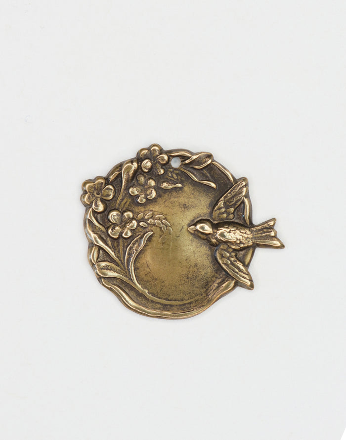 Bronze bird and floral medallion.