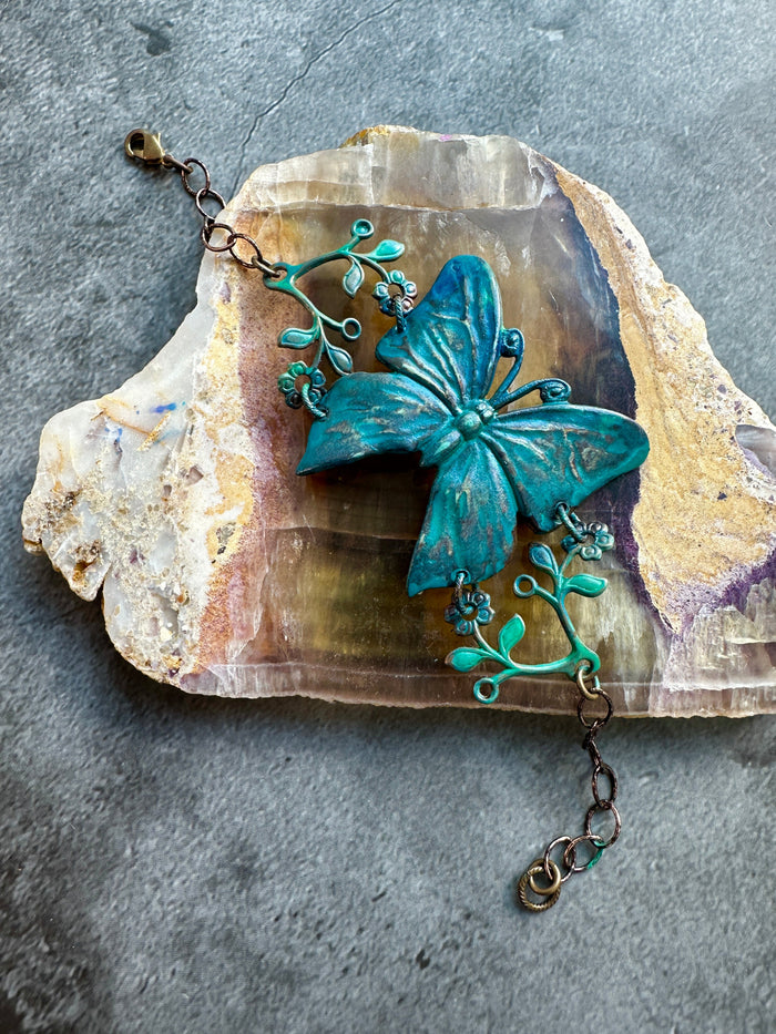 Teal butterfly bracelet on stone (18D8A516)