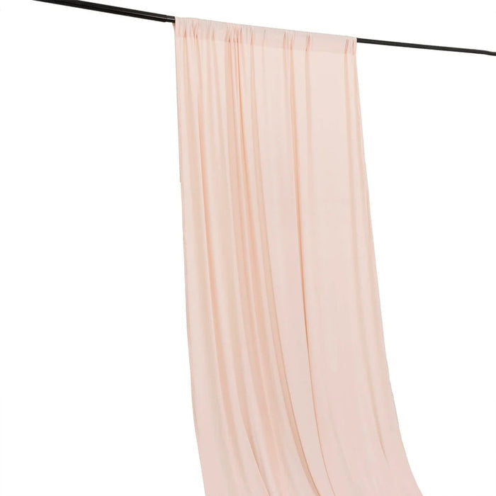 Sheer blush pink curtains hanging on a black rod against a white background