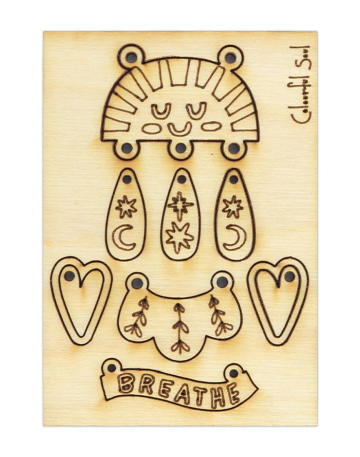 Laser-cut wooden Breathe art with sun, stars, hearts.