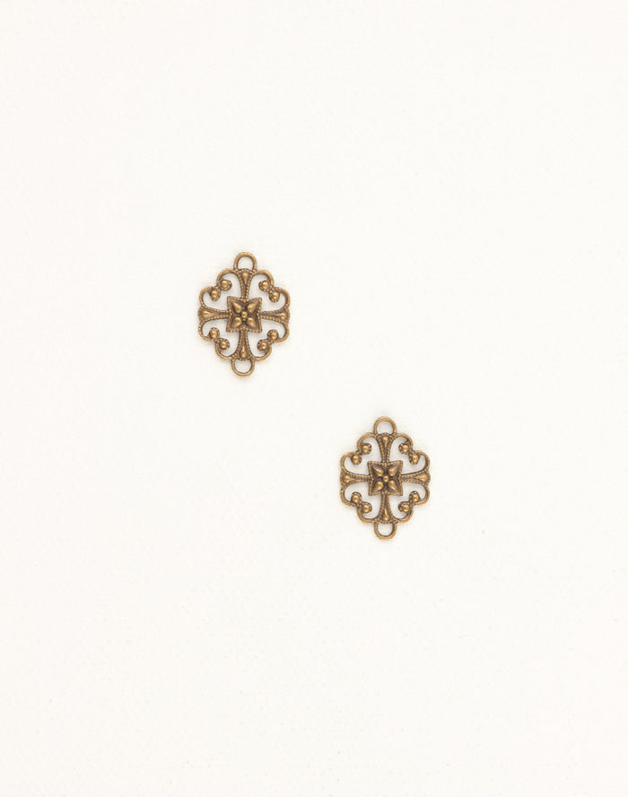 Two ornate brass filigree charms