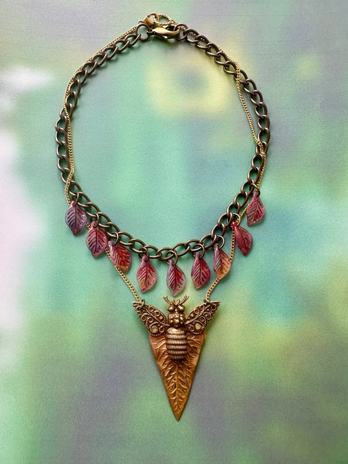 Bee pendant necklace with leaf accents.