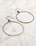 Gold hoop earrings on white marble