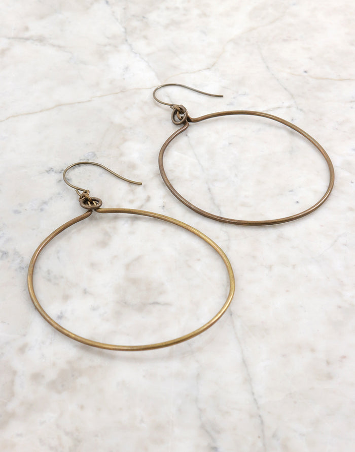 Gold hoop earrings on white marble