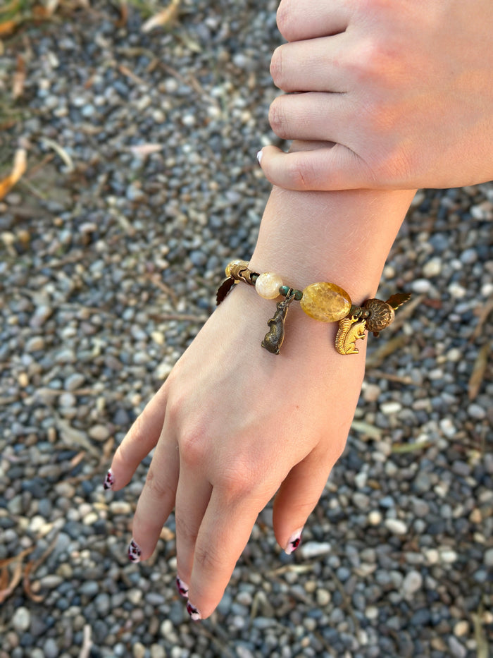 Hand wearing a beaded charm bracelet.