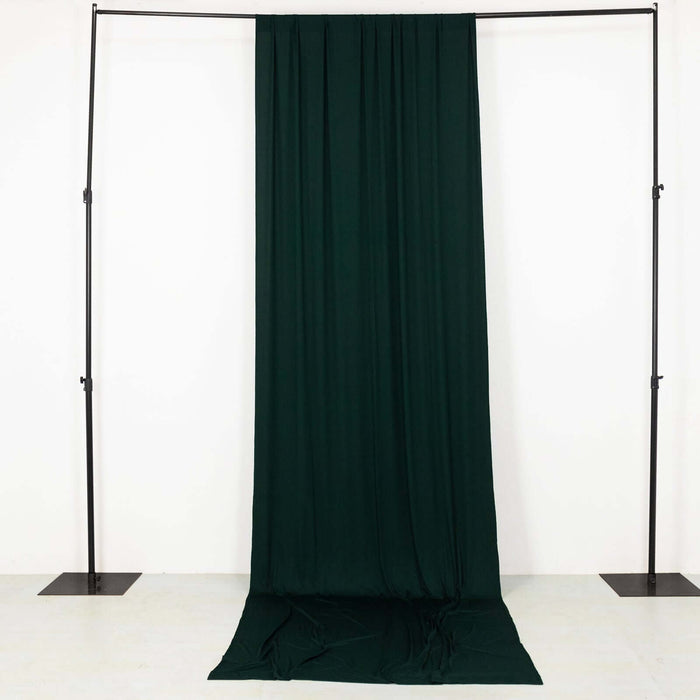 Dark green fabric draped on a studio backdrop frame