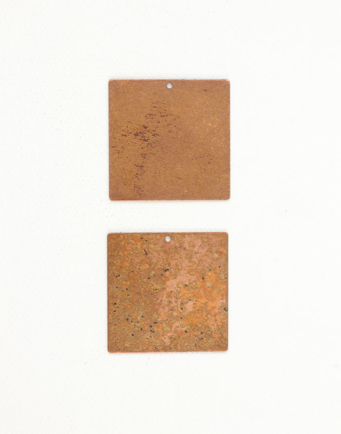 Two copper square tags
