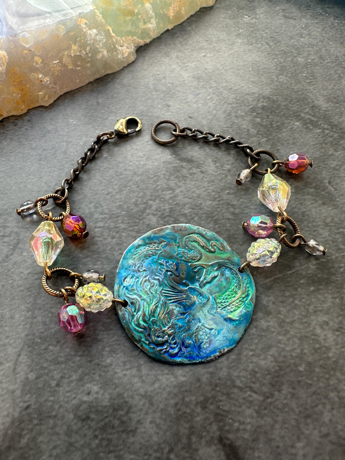 Bracelet with blue-green center and colorful beads.