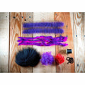 Megalolipop HD DIY Fly Tying Kit materials: neon purple marabou, black beads, and red thread on wood