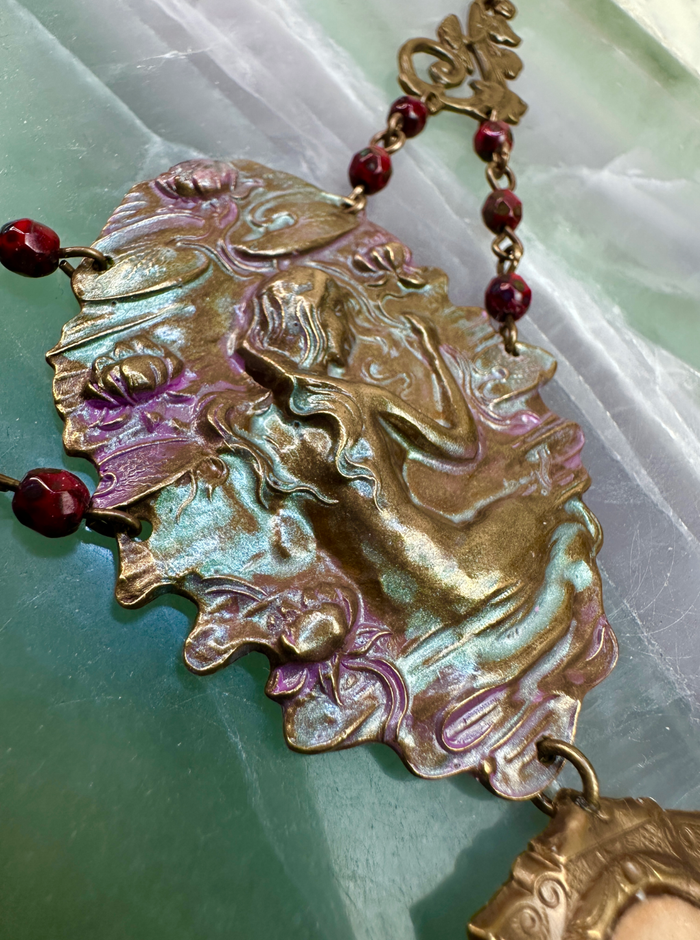 Ornate brass pendant necklace with red beads