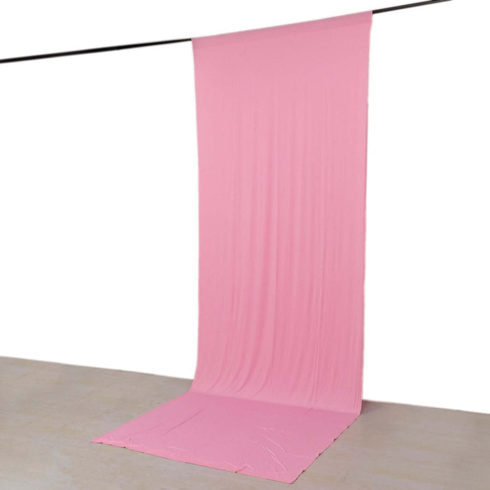 Pink fabric backdrop for photography, draped elegantly from a hanging rod.