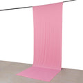 Pink fabric backdrop for photography, draped elegantly from a hanging rod.
