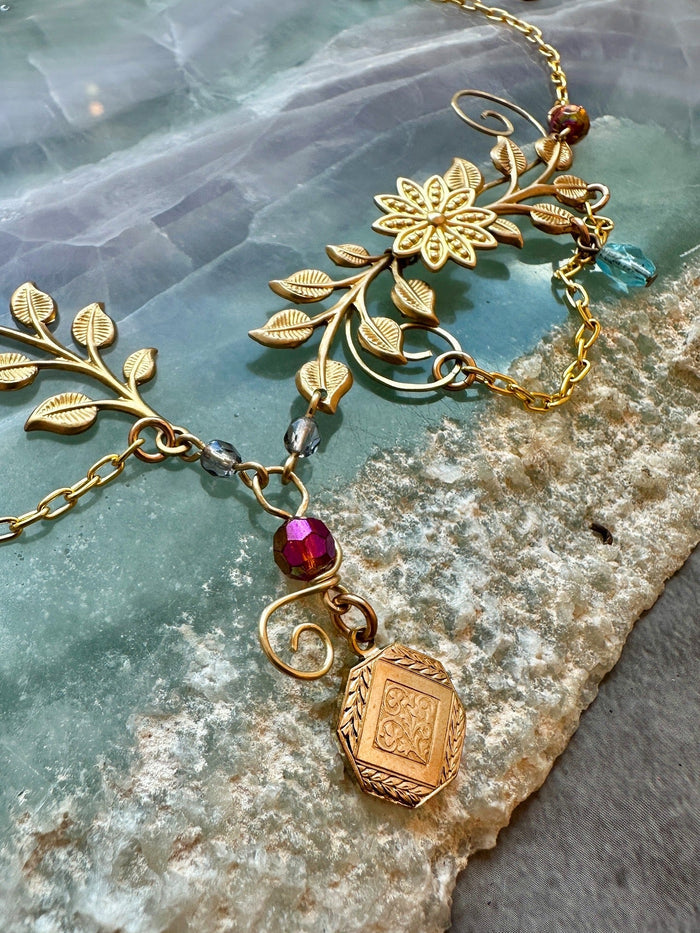 Gold necklace with floral and beaded details.