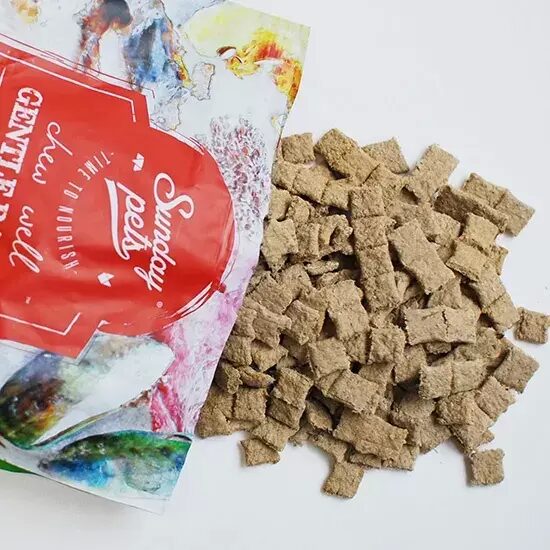 Sunday Pets Beef for Dogs treats spilled from an opened pouch, showcasing brown, pillow-shaped pieces; dehydrated, ready to serve dry or rehydrated.