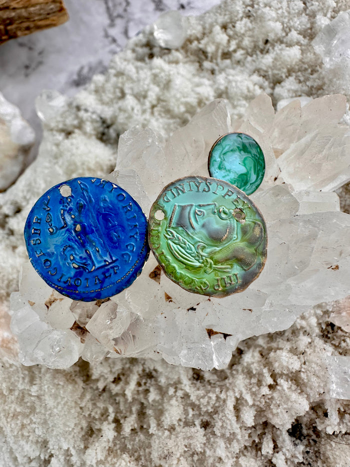 Handmade blue & green art coins on quartz crystal.