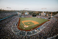 Baseball stadium during a game with a large crowd and clear sky.