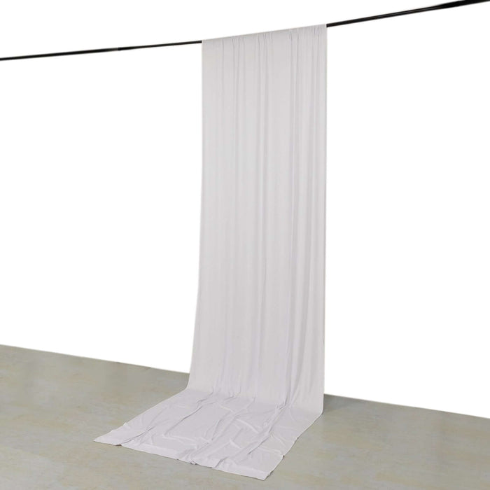 White backdrop draped fabric hanging from a rod.